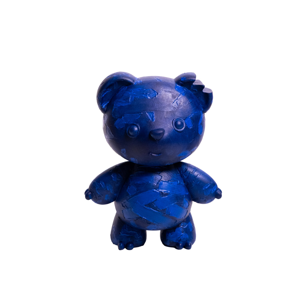 A small blue teddy bear figurine with a cracked, mosaic-like blue pattern, centered on a plain white background.