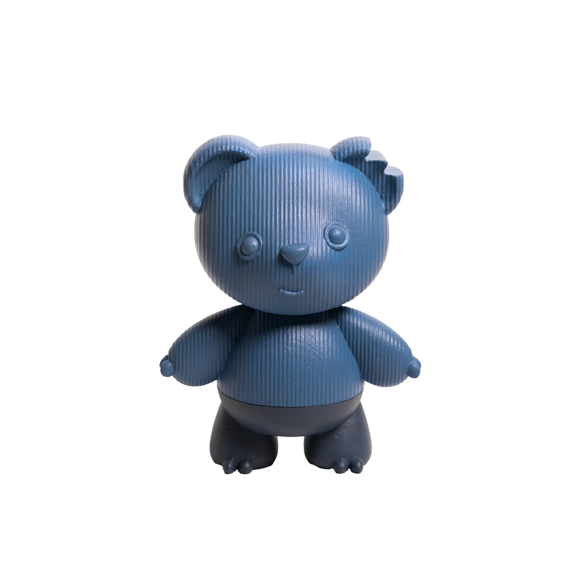 A small stylized bear figurine or toy in a textured blue color with darker gray feet, standing against a plain white background.