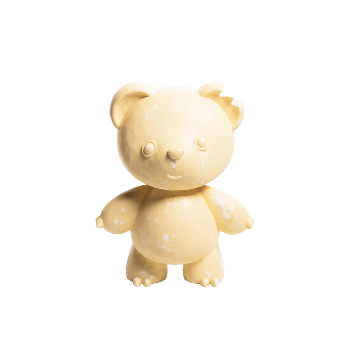 A small beige teddy bear figurine with a distressed, weathered texture, standing against a solid white background.