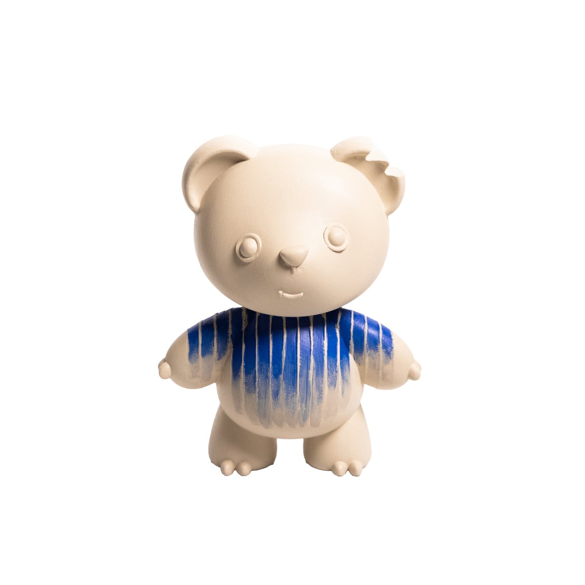 A small stylized bear figurine or plush toy with a cream-colored body and a blue striped shirt, centered on a plain white background.