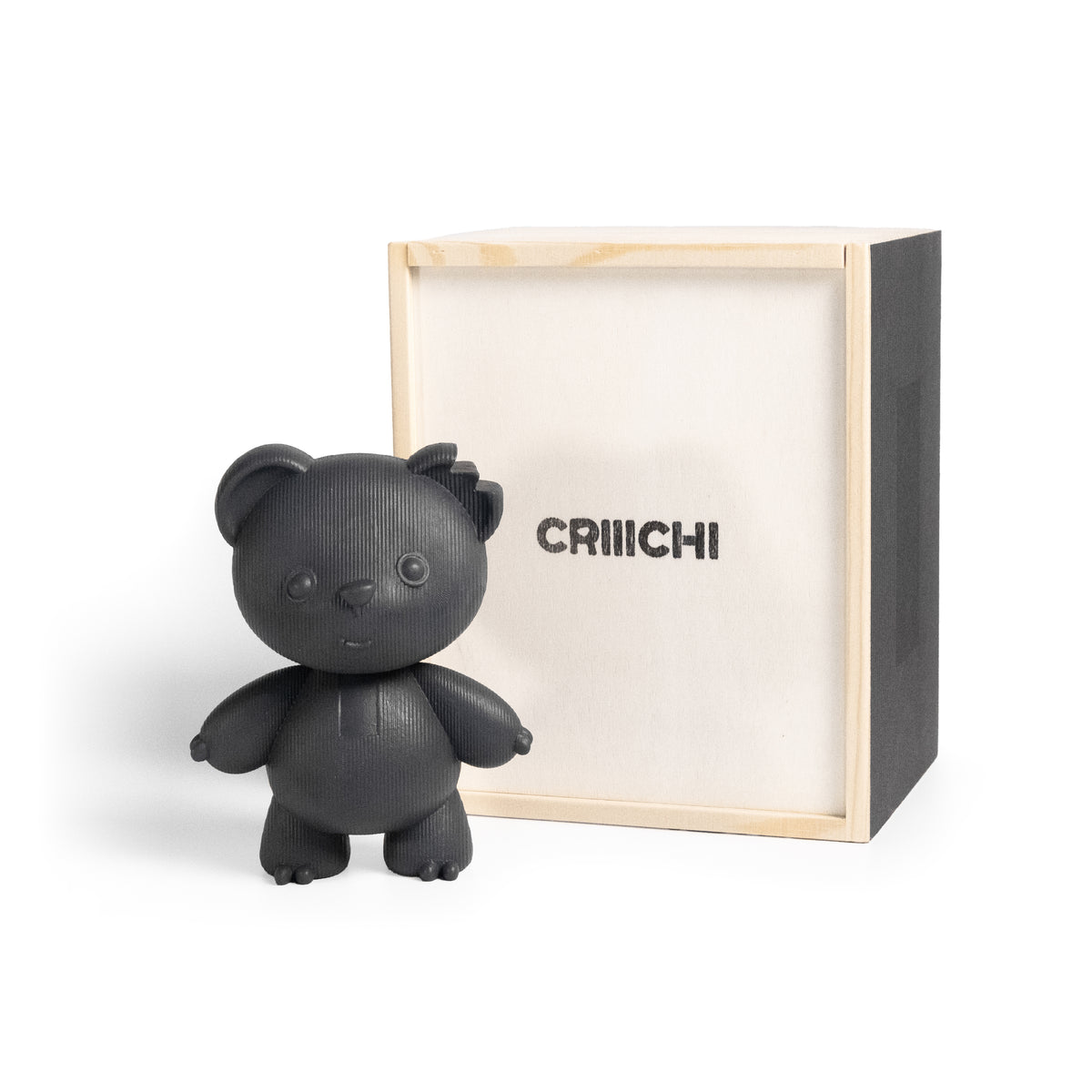 A matte black bear-shaped figurine standing in front of its light wood and black presentation box, which has the brand name 'CRIIICHI' printed on the front, set against a plain white background.