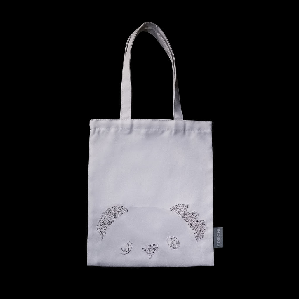 White tote bag with embroidered designs on a black background
