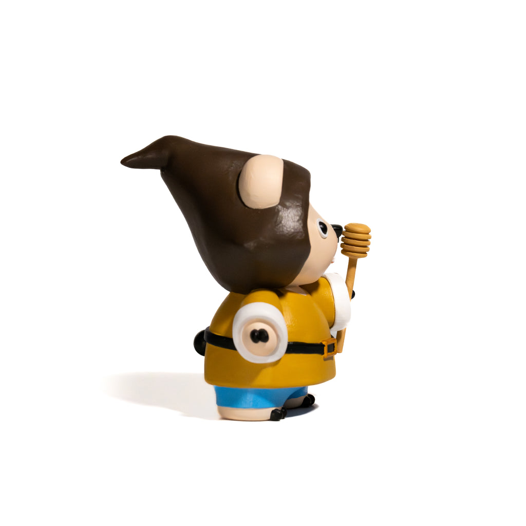 Toy figure of a bear with a pointed hat and yellow seasonal outfit 